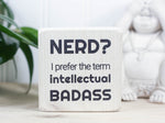 Small desk sign in whitewash with the saying "Nerd? I prefer the term intellectual badass."
