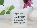 Mini wood sign in whitewash with the saying "Oops! Did I buy beer instead of milk...again?"