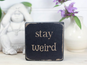 Small wooden sign in distressed black with the saying "Stay weird", the perfect gift for that special weirdo in your life.