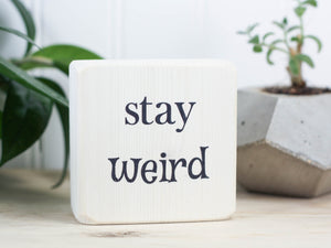 Small wooden sign in whitewash with the saying "Stay weird", the perfect gift for that special weirdo in your life.