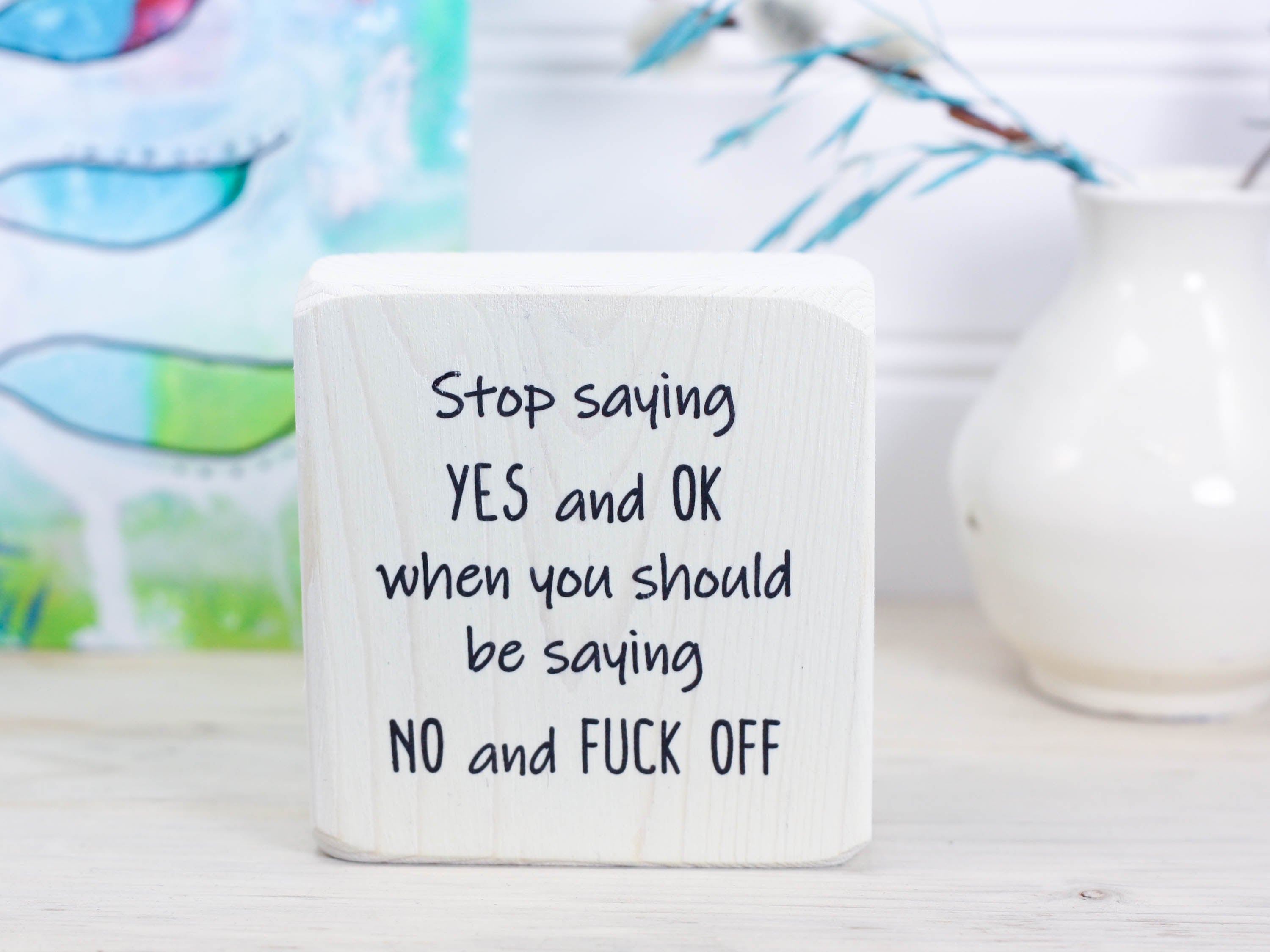 Small whitewash freestanding wood sign with the text "stop saying yes and ok when you should be saying no and fuck off"