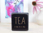 Mini wood sign in distressed black with the saying "TEA a hug in a mug".