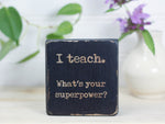 Mini wood sign in distressed black with the saying "I teach. What's your superower?"