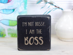 Small distressed black freestanding wood sign with the text "I'm not bossy. I am the boss"