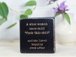 Small freestanding distressed black wood sign with the saying "A wise woman once said "fuck this shit" and she lived happily ever after