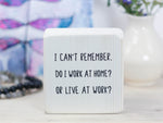 Small, freestanding whitewash wood sign with a funny saying on it "I can't remember. Do I work at home? Or live at work?"